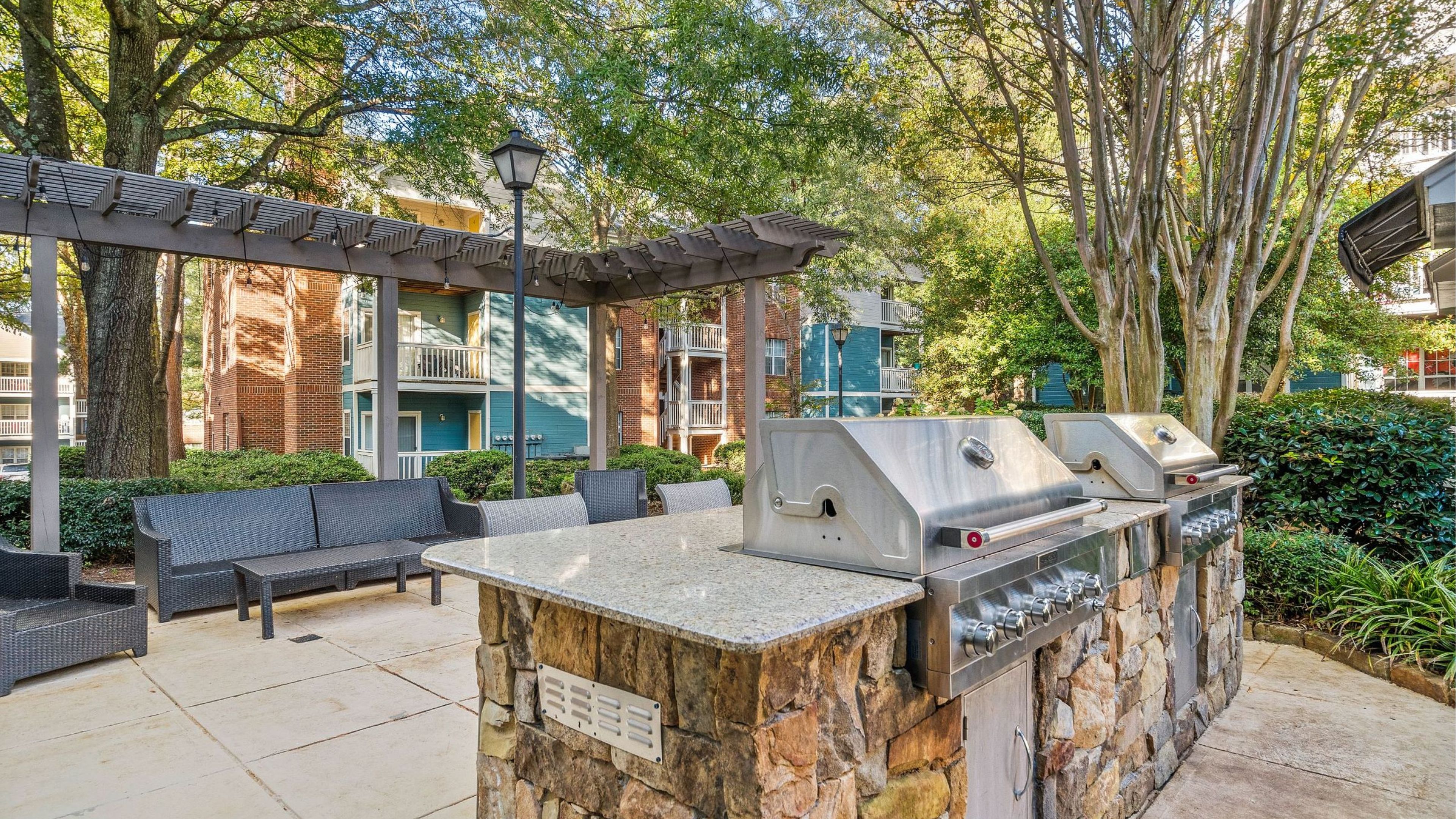 Hawthorne at the Park outdoor grilling area resident amenity with seating and beautiful stonework.
